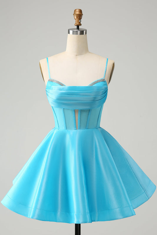 Robe de soirée bustier courte avec bretelles fines, en tulle pailleté bleu, coupe trapèze et ornée de perles