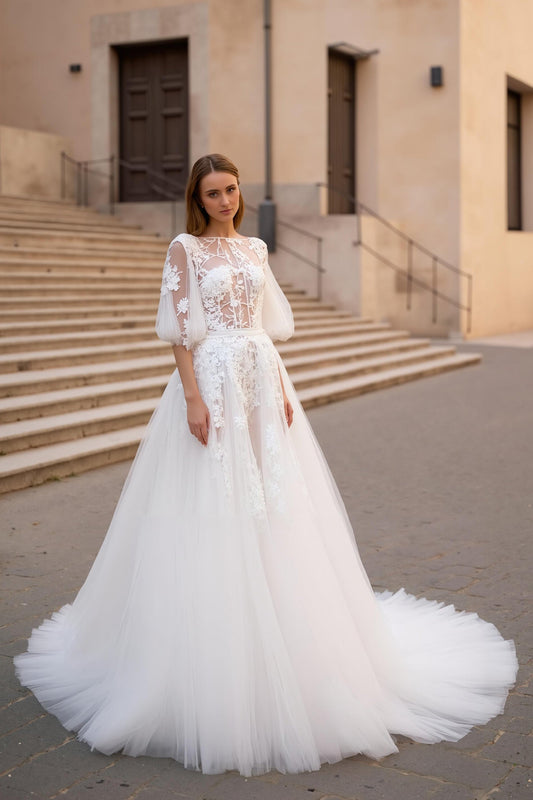 Robe de mariée florale ivoire à manches, avec appliqués, coupe trapèze et traîne.