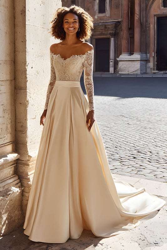 Robe de mariée princesse satinée champagne à épaules dénudées, manches longues et traßne avec dentelle