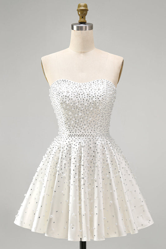 Robe de bal courte blanche sans bretelles, coupe trapèze, ornée de perles et de volants