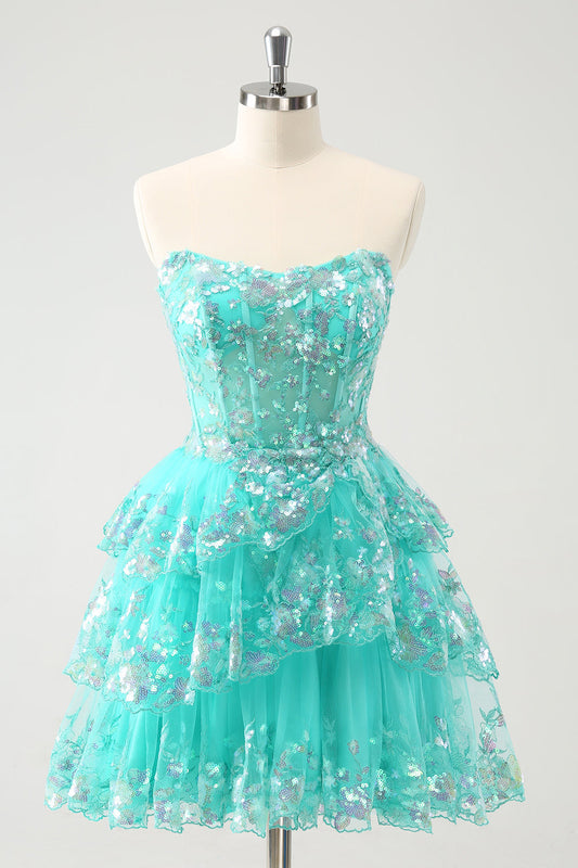 Mignonne robe de bal bustier trapèze verte à paillettes, à volants étagés et corsage en sequins