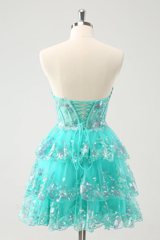 Mignonne robe de bal bustier trapèze verte à paillettes, à volants étagés et corsage en sequins