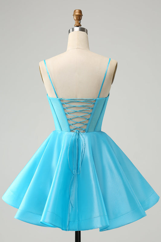 Robe de soirée bustier courte avec bretelles fines, en tulle pailleté bleu, coupe trapèze et ornée de perles