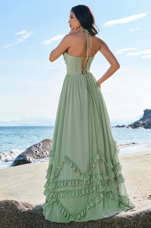 Robe de demoiselle d'honneur longue en mousseline fendue avec corset dos-nu coupe trapèze et volants vert sauge poudré