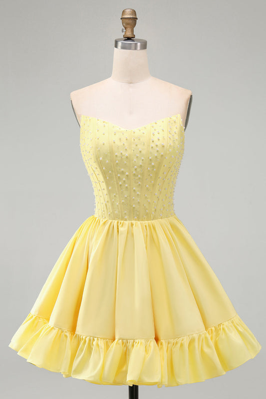 Robe courte de soirée jaune avec jupe trapèze, bustier sans bretelles, perles et volants