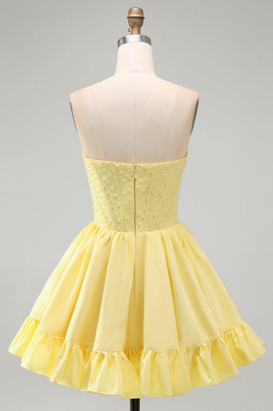 Robe courte de soirée jaune avec jupe trapèze, bustier sans bretelles, perles et volants