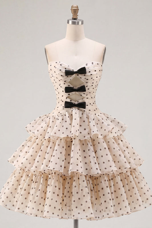 Robe de cocktail en mousseline étagée, coupe trapèze, bustier cœur, motif pois noirs, couleur abricot, avec nœud.