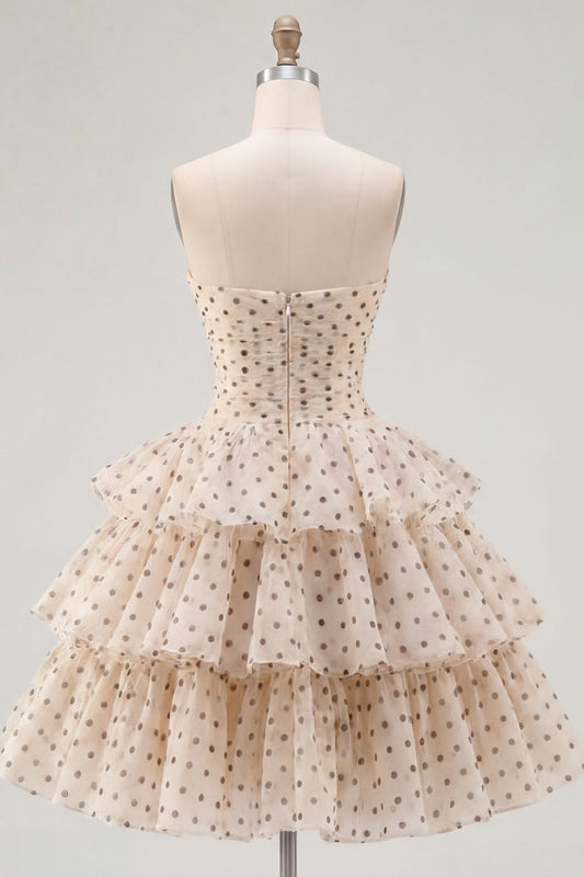 Robe de cocktail en mousseline étagée, coupe trapèze, bustier cœur, motif pois noirs, couleur abricot, avec nœud.