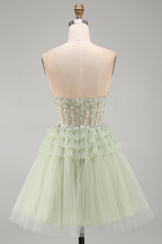 Robe de bal bustier coupe trapèze vert sauge avec corset, fleurs, volants et perles