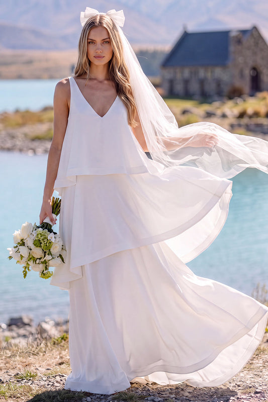 Robe de mariée longue et fluide sans manches à col en V blanc avec volants, idéale pour une fugue amoureuse