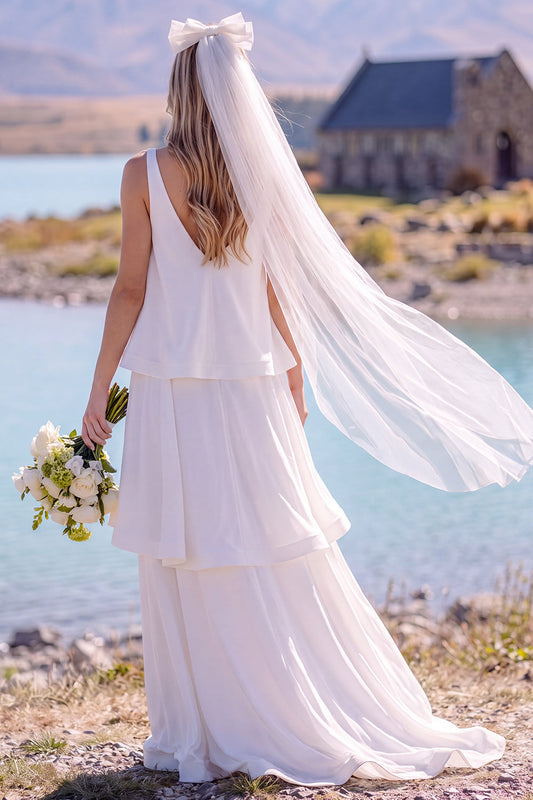 Robe de mariée longue et fluide sans manches à col en V blanc avec volants, idéale pour une fugue amoureuse