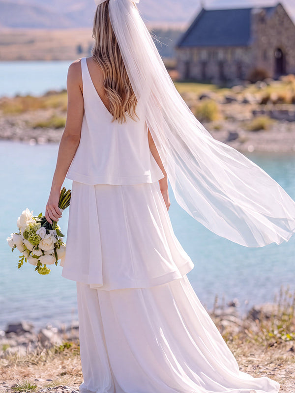 Robe de mariée longue et fluide sans manches à col en V blanc avec volants, idéale pour une fugue amoureuse