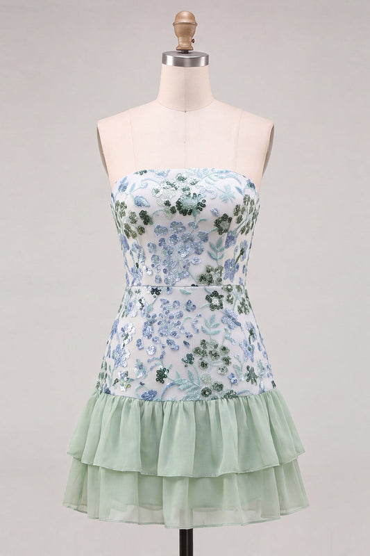 Robe courte de cocktail vert clair, sans bretelles, coupe trapèze, à volants étagés, ornée de sequins.