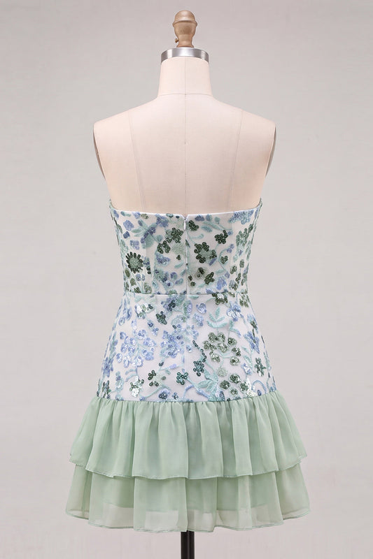 Robe courte de cocktail vert clair, sans bretelles, coupe trapèze, à volants étagés, ornée de sequins.
