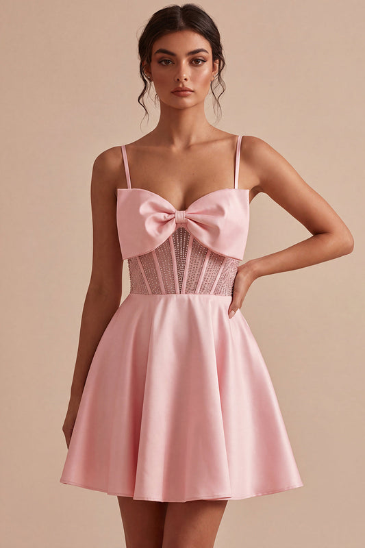 Robe de bal courte rose en ligne A avec corset transparent, volants, perles et nœud