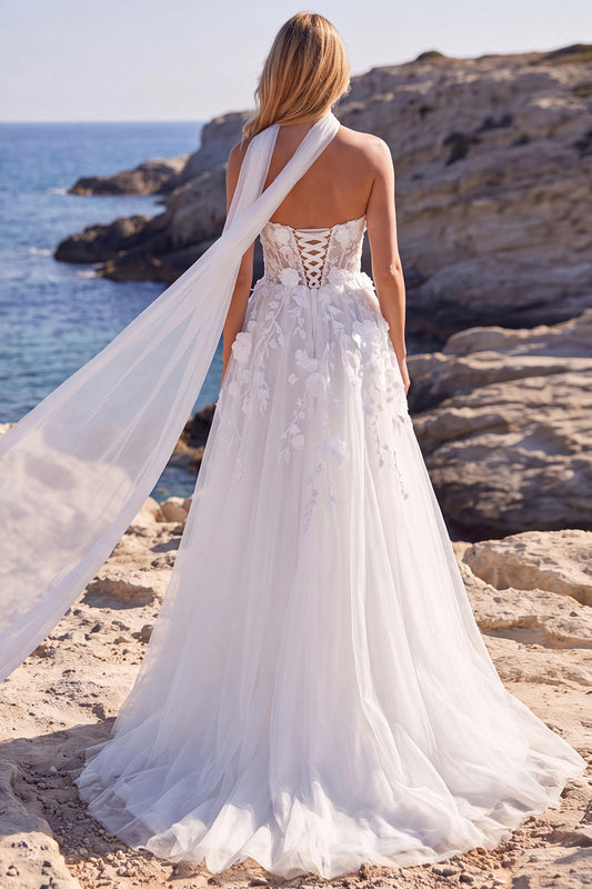Robe de mariée longue blanche en tulle coupe évasée, ornée de fleurs, corsage cœur et appliqués