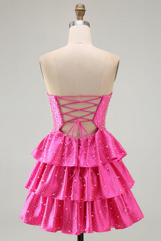 Robe de bal fuchsia à volants étagés, ornée de perles, avec découpes et coupe trapèze perlée