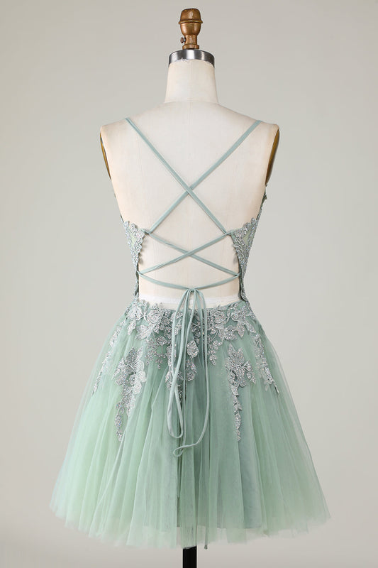 Robe de bal courte verte avec fines bretelles, coupe trapèze et appliques